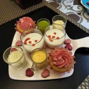 "Dessertplateau met kleurrijke hapjes in glaasjes, cupcakes met roze topping en hartvormige chocolaatjes, geserveerd in een koffiehuis "koffie & meer" te Lier